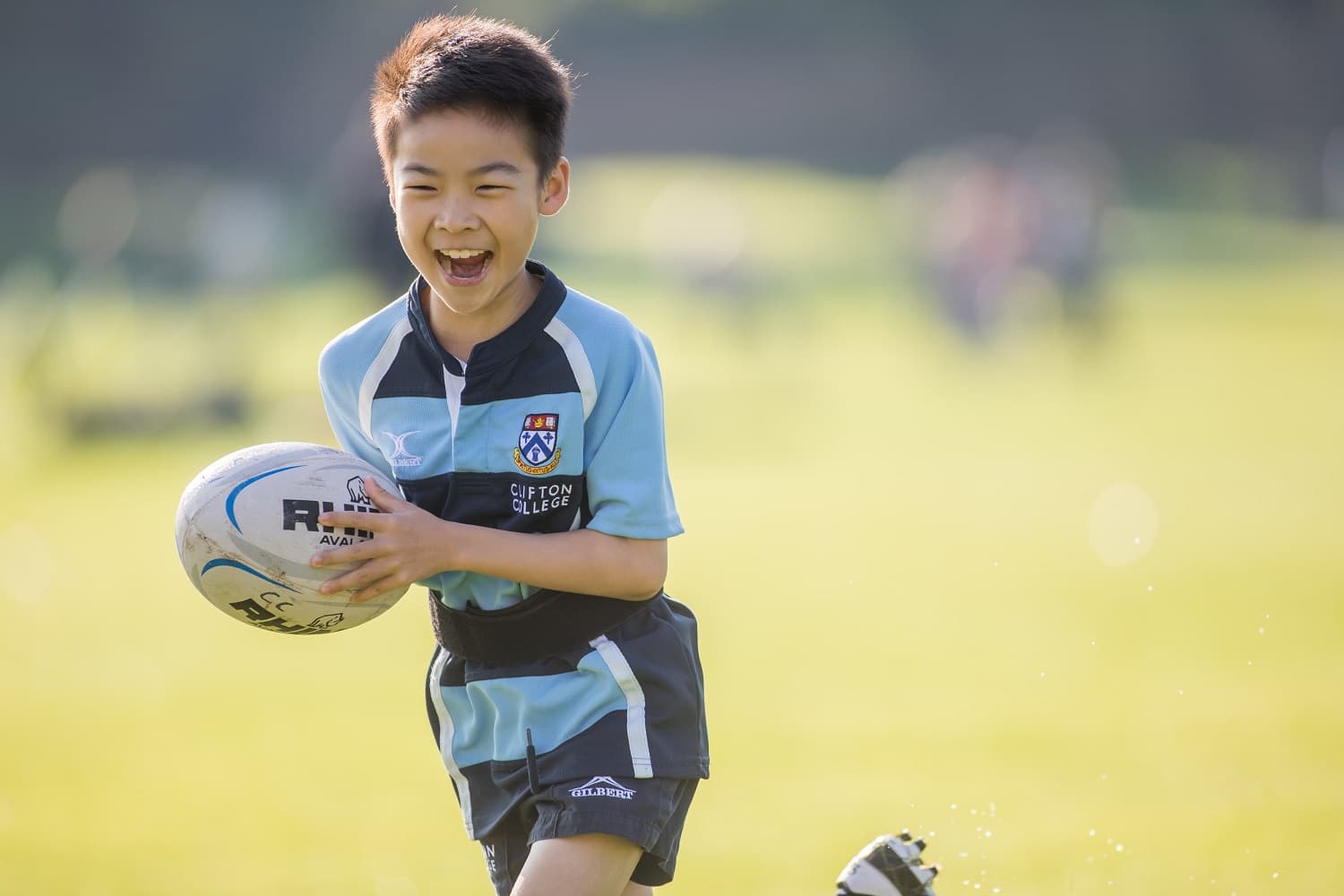Boy playing rugby and smiling